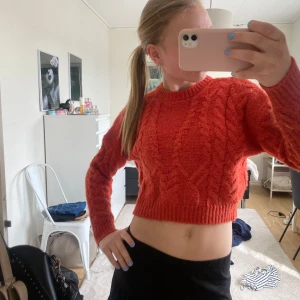  röd stickad tröja - Säljer en röd stickad tröja med kabelstickat mönster. Tröjan har långa ärmar och rund halsringning. Perfekt för dig som vill ha en trendig och mysig look.