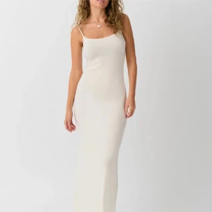 Vit långklänning med smala axelband - Elegant vit långklänning med smala axelband och figurnära passform. Klänningen har en minimalistisk design och är perfekt för sommarens tillfällen. Tillverkad i ett mjukt och följsamt material som ger en stilren siluett.💞💞