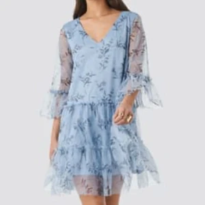 Ljusblå klänning - Väldigt smickrande blå klänning med fina blommor på. Pösig i passformen. Sparsamt använd och i väldigt fint skick. 