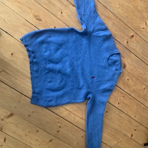 Blå kashmirtröja från Ralph Lauren - Säljer en mjuk blå kashmirtröja från Ralph Lauren med den klassiska röda broderade loggan på bröstet. Tröjan har rund halsringning och långa ärmar. Perfekt för dig som gillar stilrena och bekväma plagg. Äkta