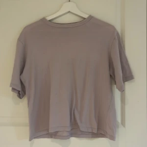 Ljuslila t-shirt från 157 - En basic ljuslila t-shirt från 157 i 100% bomull. T-shirten har en avslappnad passform och korta ärmar, perfekt för en enkel och stilren look. Snygg att matcha med jeans eller shorts.