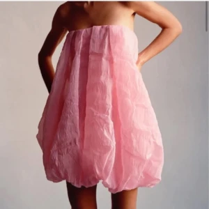 Rosa bubblig kortklänning - Säljer en superfin rosa kortklänning med bubblig ballongform och axelbandslös design. Klänningen har en luftig och voluminös siluett som verkligen sticker ut. Perfekt för dig som vill ha något unikt och lekfullt!