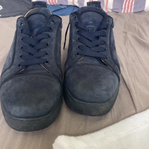  Christian Louboutin - Säljer ett par mörkblå skor från Christian Louboutin i mocka med  röda sulor.