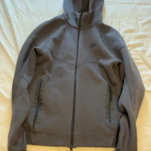 Nike tech  - Säljer en helt oanvänd Nike tech tröja i storlek S i mörk grå färg 