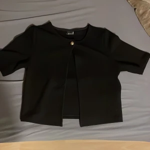 Svart kortärmad topp - En elegant topp för en stilren look. Har bara använt den en gång på nyår❤️Mina mått finns på min bio🫶priset kan diskuteras 