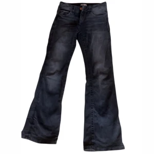 Svarta bootcut jeans - Snygga svarta bootcut jeans från gina tricot de med klassisk femficksdesign och knappgylf. Jeansen har en lätt utsvängd passform som ger en retro känsla. Perfekta för en avslappnad stil.