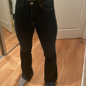 Mörkblå bootcut jeans - Snygga mörkblå bootcut jeans med hög midja och klassisk femficksdesign. Perfekta för en stilren look med en touch av retro. Passar bra till både sneakers och klackar.