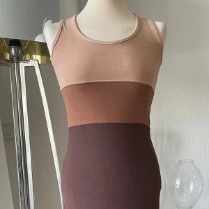 Flerfärgad ärmlös lång klänning S  - Snygg ärmlös klänning i flera nyanser av brunt och beige. Klänningen har en tight passform och är gjord i ett mjukt, stretchigt material. Perfekt för en stilren look. Alla lappar är bortklippta 