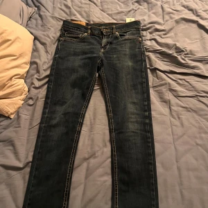 Dondup jeans! W28 - Snygga mörkblå jeansbyxor med klassisk femficksdesign och kontrastsömmar. De har en dragkedja och knapp framtill. Perfekta för en avslappnad stil.