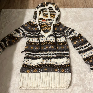 Mönstrad stickad hoodie - Säljer en mysig stickad hoodie med ett  mönster i grått, vitt och orange.