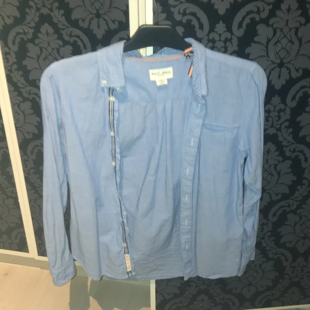 Snygg ljusblå skjorta från Ralph Lauren med klassisk krage och knappar framtill. Skjortan har en bröstficka och är perfekt för en stilren look. Passar bra till både jeans och chinos.. Paidat.