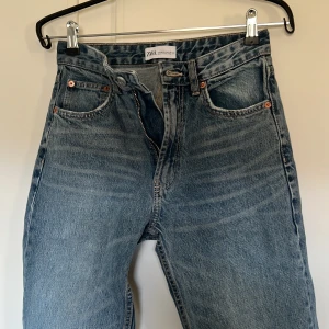 Blå jeans från Zara - Säljer ett par klassiska blå jeans från Zara. De har en rak passform med dragkedja och knapp framtill. Jeansen har fem fickor och är perfekta för en avslappnad stil. Passar till många olika outfits! Väldigt snygg tvätt! 