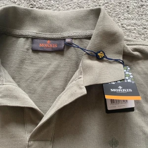 pikétröja från Morris - Säljer en stilren grön pikétröja från Morris. Tröjan har en klassisk krage och korta ärmar, perfekt för en avslappnad men ändå snygg look. Märket är diskret placerad på bröstet. Passar utmärkt för både vardag och lite finare tillfällen. Ny pris 799 och tröjan är inprincip oanvänd