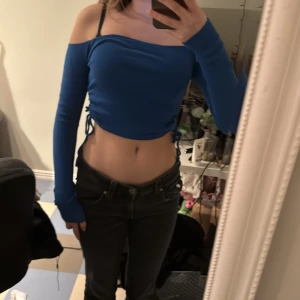 Blå offshoulder topp från newyorker - Snygg blå offshoulder topp från newyorker med långa ärmar och knytning i sidorna.