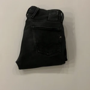 Replay anbasss - Snygga svarta jeans från Replay i modellen Anbass. De har en slim passform och är tillverkade i ett stretchigt material för extra komfort. Perfekta för en stilren look. Även feta slitningar 🙌🏻