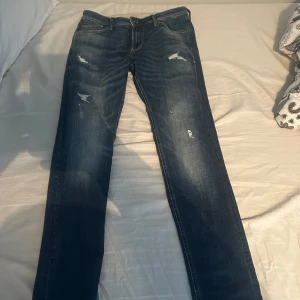 Jack & Jones jeans med slitningar - Snygga blå jeans med slitningar för en trendig look. De har en klassisk femficksdesign och en knappgylf. Perfekta för en avslappnad stil.