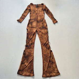 Jumpsuit - Vintage glittrig bootcut jumpsuit från Maziloum. Passar storlek S/M. Mått från armhåla: 42 cm. Total längd (från axel): 147 cm. Innerbenslängd: 80 cm. Min vän på bilderna är 161 cm lång