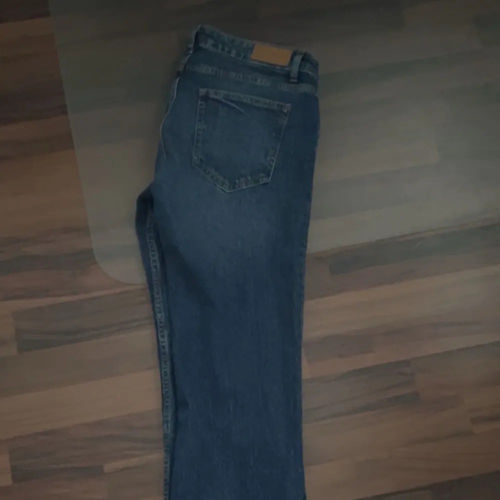 Snygga blå jeans från Pull&Bear med klassisk femficksdesign och knappgylf. De har en rak passform och är perfekta för en avslappnad stil. Jeansen har en mörk tvätt som ger en snygg look.. Farkut & Housut.