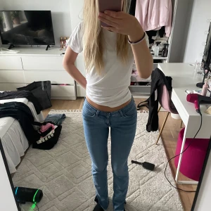 Ljusblå raka jeans från Lee - Säljer ett par ljusblå jeans från Lee med klassisk femficksdesign och låg midja. Jeansen har raka ben och sitter snyggt över höfterna. Tillverkade i mjukt denimtyg som är skönt att bära hela dagen. Gjort om till slits nertill