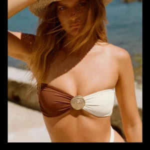 Brun/vit bandeau bikini topp - Snygg bandeau bikini i brunt och vitt. Köpt till denna sommar men användes aldrig, säljer därav den. Storlek XS. Nypris: 329kr💓