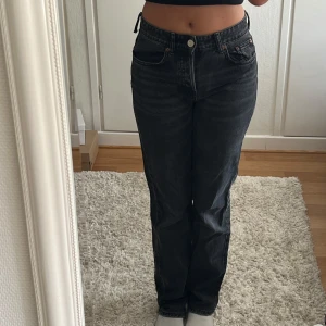 Svarta raka mid-rise jeans från Zara - Säljer ett par svarta jeans från Zara med rak ben och medelhög midja. En ögla till skärpet har lossnat (se bild) men kan lätt sys fast/klippas av om man vill. 