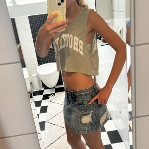 Grön croppad linnetopp Navigator - Säljer en ljusgrön croppad linnetopp från Navigator med trycket 'BROOKLYN' i vitt framtill. Toppen är ärmlös med breda ärmhål och har en avslappnad, loose passform. Perfekt för varma dagar och enkel att styla med jeans eller kjol.