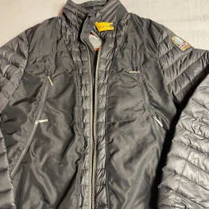 Svart dunjacka från Parajumpers  - Snygg svart dunjacka från Parajumpers i modellen Giuly. Jackan har quiltade partier, flera dragkedjeförsedda fickor och coola detaljer som logopatch på ärmen. Lätt och smidig med featherweight-känsla, perfekt för kyliga dagar. Jackan saknar en dragkedja