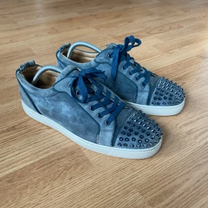 Blå Christian Louboutin skor - Väldigt eftertraktade Christian Louboutin skor i färgen washed blue. Skorna är i bra skick men finns lite skavanker som att färgen på vissa spikar har gått bort. Skorna har lite heal drag som jag kan skicka bild på. Finns även lite märken på skorna. (Se bilder) Storlek 43 1/2 men passar även 44. Tveka inte att kontakta vid minsta lilla fundering. 