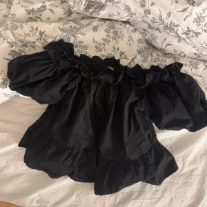 Svart offshoulder blus med volang - Supersöt svart blus med offshoulder och puffiga ärmar. 