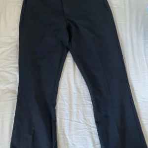 Svarta kostymbyxor bootcut - Snygga svarta kostymbyxor med bootcut. Midja är midwaist