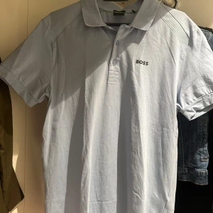 Ljusblå boss pikétröja - Snygg ljusblå pikétröja från boss. Lite skrynklig men jag stryker den innan jag levererar den, ifall man vill såklart.