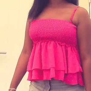 Rosa volangig linnetopp - Supersöt rosa linnetopp med smockad överdel och tunna axelband. 