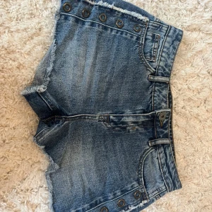 Högmidjade jeansshorts från Amisu - Snygga blå jeansshorts från Amisu med hög midja och fransiga kanter. Shortsen har coola metallöljetter längs sidorn. Perfekta för sommaren 💕💕