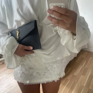 Vit paljettkjol med kort modell - Supersnygg vit minikjol täckt av stora paljetter som ger ett glittrigt och festligt intryck. Kjolen har en tight passform och är perfekt för dig som vill sticka ut. Den är kort och sitter högt i midjan, vilket ger en fräsch och trendig look🤍🤍