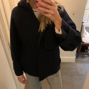 Mörkblå jacka med huva från COS - Supersnygg jacka med huva från COS! Storleken är xs, men den passar bra även på mig som är 173 cm! Den är i mycket bra skick! Nypris 1800 kr💓💓 