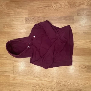 Mörkröd Champion hoodie L - Säljer en mörkröd hoodie från Champion i modellen Reverse Weave. Tröjan har krympt lite    i tvätten så är nu mera L i storlek.