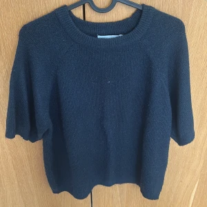 Mörkblå stickad tröja från 157 - Mysig mörkblå stickad tröja från 157 med rund halsringning och kortare ärmar. Passar med jeans. 