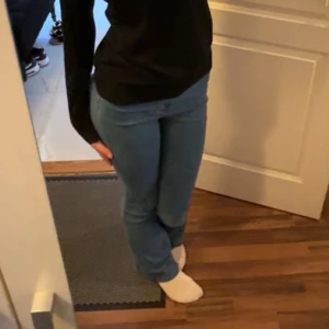 Blåa bootcut jeans med hög midja - Säljer ett par klassiska blå jeans med bootcut-modell och hög midja. Jeansen har en tight passform upptill och släpper ut vid bensluten. De är tillverkade i stretchigt denimtyg och har bakfickor samt bälteshällor. Väldigt stretchiga!