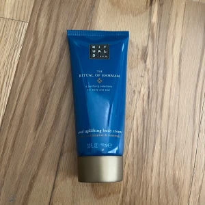Rituals The Ritual of Hammam body cream - En lyxig blå tub med The Ritual of Hammam soul uplifting body cream från Rituals. Innehåller doft av eucalyptus och rosmarin. Tuben har guldfärgat lock och rymmer 70 ml. Perfekt för dig som vill ha en fräsch och upplyftande känsla till kroppen. Plomberingen är borttagen då jag ville veta hur den luktade men den är helt oanvänd och ny 