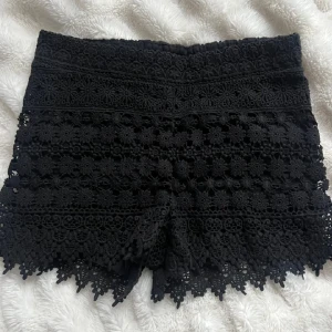 Svarta spets shorts - Svarta högmidjade shorts med  spets och broderade blommor. Väldigt fina nu till sommaren, dock utan dragkedja och är rätt små i storlek. Bilderna ovan är lånade men mina shorts ser exakt likadana ut🥰💞