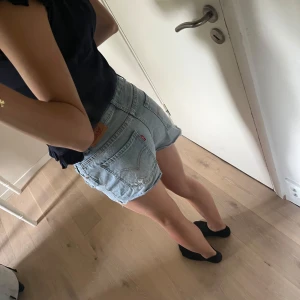 Levi's ljusblå jeansshorts Girlfriend - Snygga ljusblå jeansshorts från Levi's modell Girlfriend Shorty. Storleken passar allt mellan 32-36. Perfekta för sommaren med en avslappnad och trendig vibe. Fråga gärna vid funderingar. Pris kan alltid diskuteras💓