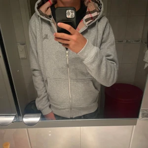 Grå Burberry zip hoodie - Säljer en grå burberry zip. Storlek M och passar som M. Helt ny nästan aldrig använd, kvalitet 10/10. Pris kan diskuteras.