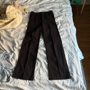 Svarta kostymbyxor från Kappahl - Svarta kostymbyxor från Kappahl i klassisk rak modell. Byxorna har pressveck och vida ben för en clean och stilren look. Perfekta till en snygg skjorta eller stickad tröja. Materialet känns mjukt och följsamt. Pris kan diskuteras 