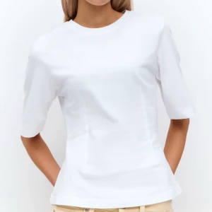 Vit topp - Snygg vit t shirt från gina tricot med sömmar vid midjan som visar lite figur, väldigt mjukt material och funkar till skola, middag och massa andra tillfällen. Går enkelt att styla och sitter fint! 