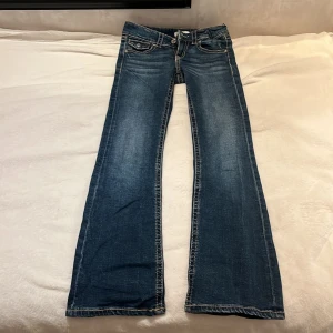 Blå bootcut jeans från Gina Tricot - Snygga blå bootcut jeans från Gina Tricot med klassisk femficksdesign och coola bakfickor med lock och knapp. Jeansen har kontrastsömmar och en lätt tvättad look. Perfekta för dig som gillar en avslappnad men trendig stil. Jeansen är i väldigt bra skick, och är använda ett par gånger. Säljer för de är för korta❤️