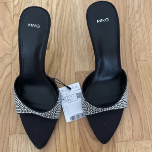 Klackar - Klackskor  - Glittriga klackar med öppen tå ifrån mango. Storlek 40. De är helt oanvända med prislappen kvar, då de vart lite för stora för mig.