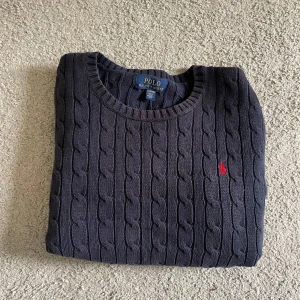Mörkblå kabelstickad tröja Polo Ralph Lauren - Kabelstickad mörkblå tröja från Polo Ralph Lauren. Den är i perfekt skick med inga skador skriv till mig vid frågor 💛💛💛
