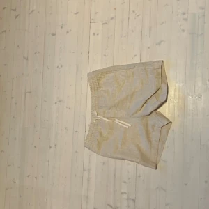 Beige linneshorts  - Snygga och luftiga beige shorts i linne med elastisk midja och snörning framtill. Perfekta för varma dagar och ger en chill vibe. Klassisk passform och neutrala färger gör dem enkla att matcha med allt.(Ser fläckiga ut på bilderna men det är endast pga ljuset)