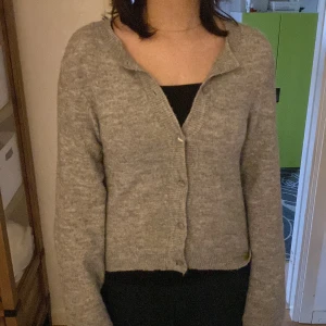 Grå kofta från hm , stickad - Mysig grå stickad kofta från hm med knappar framtill. Klassisk modell med lång ärm och ribbade muddar. Perfekt att slänga över en topp för en chill look. Enkel att matcha med det mesta och superbekväm.