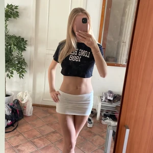 Svart croppad t-shirt med vit text - Jättefin croppad T-shirt som funkar till vardags, fest, semester, dans eller till och med spex. Tröjan kan stylas med allt möjligt och är väldigt bra nu till sommaren med tanke på att den är väldigt luftig.